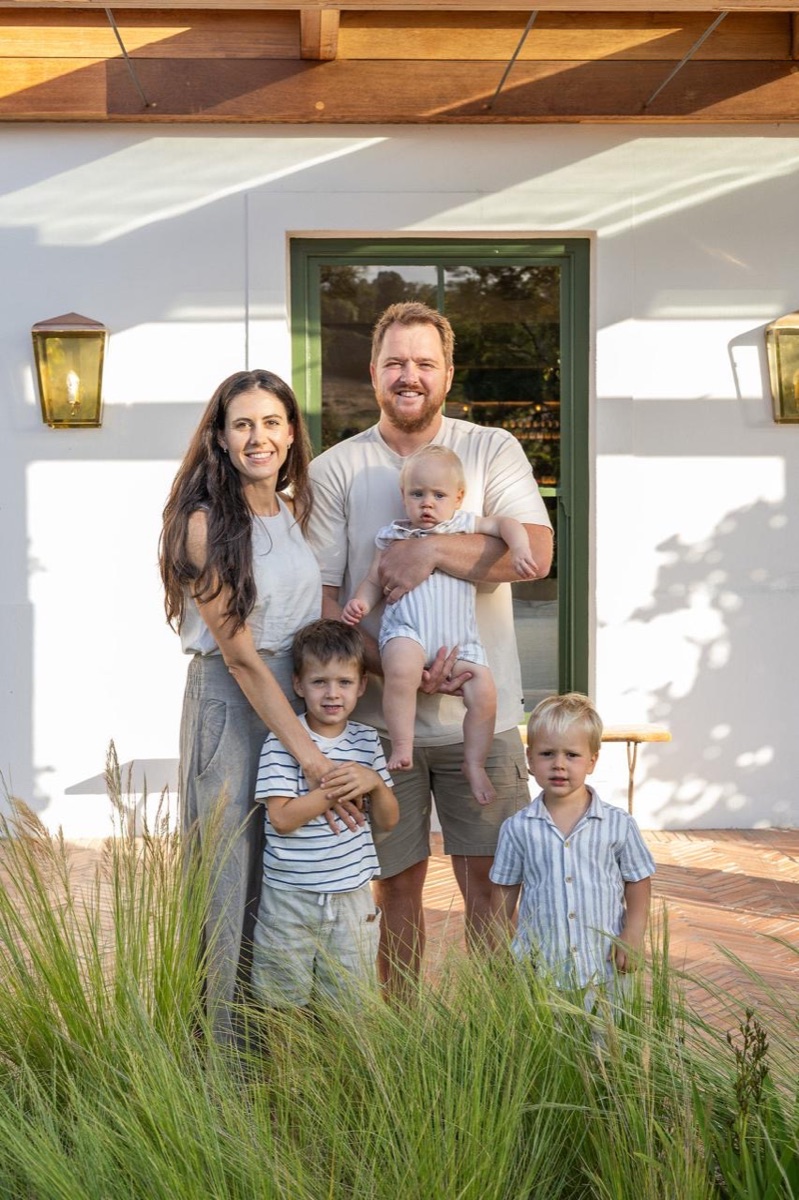A family of five outside a whitewashed farmhouse in the late afternoon